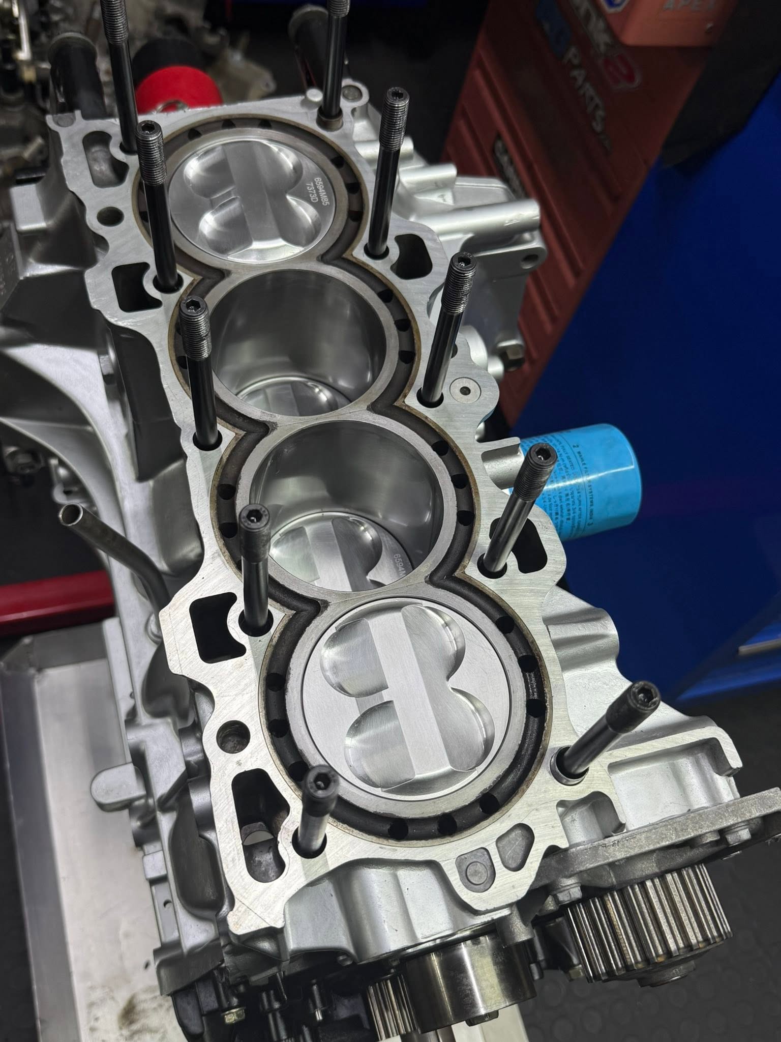 Assembled B-series short block with installed pistons and head studs.