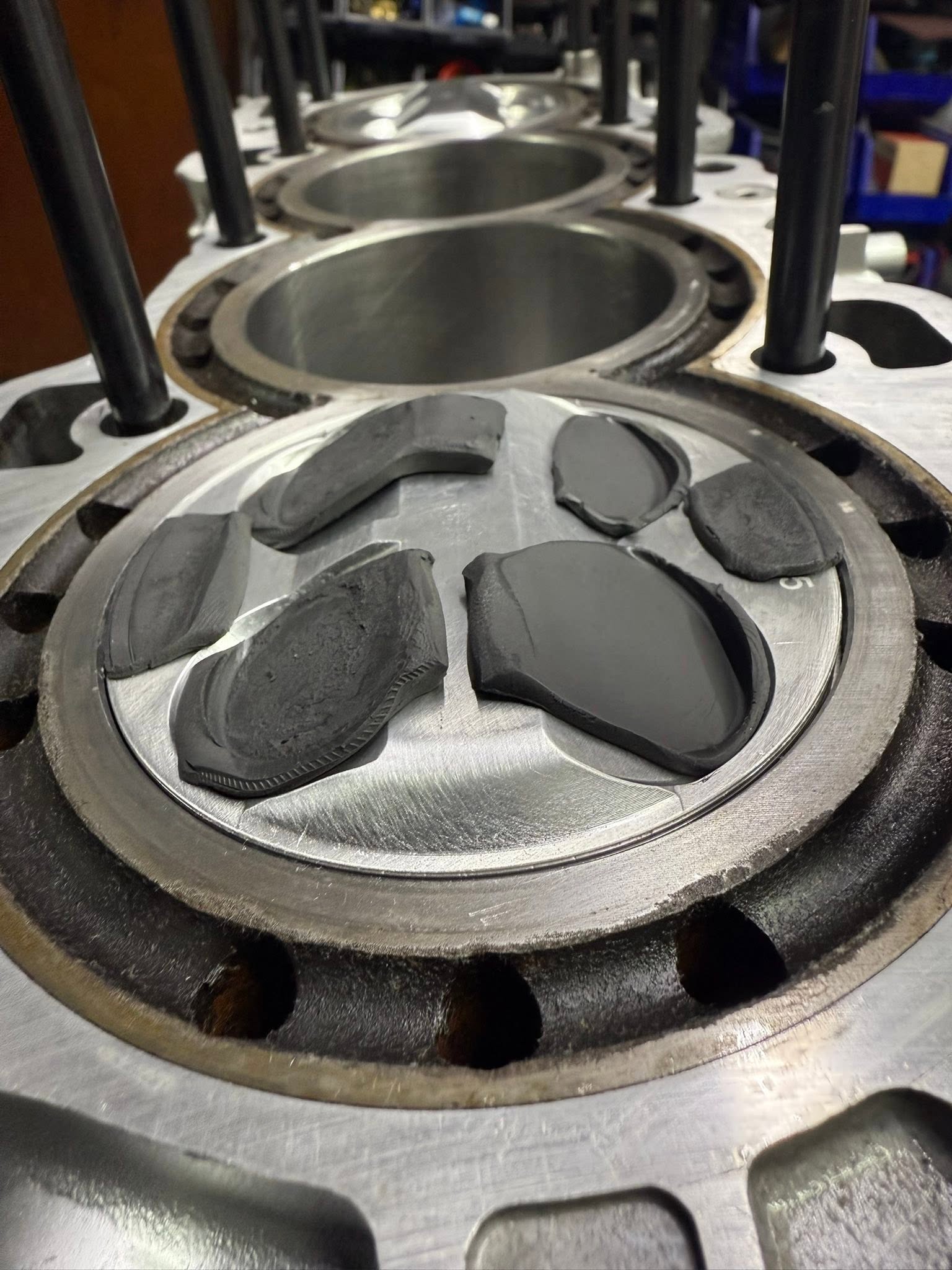 Piston crowns with checking compound and valve impressions.