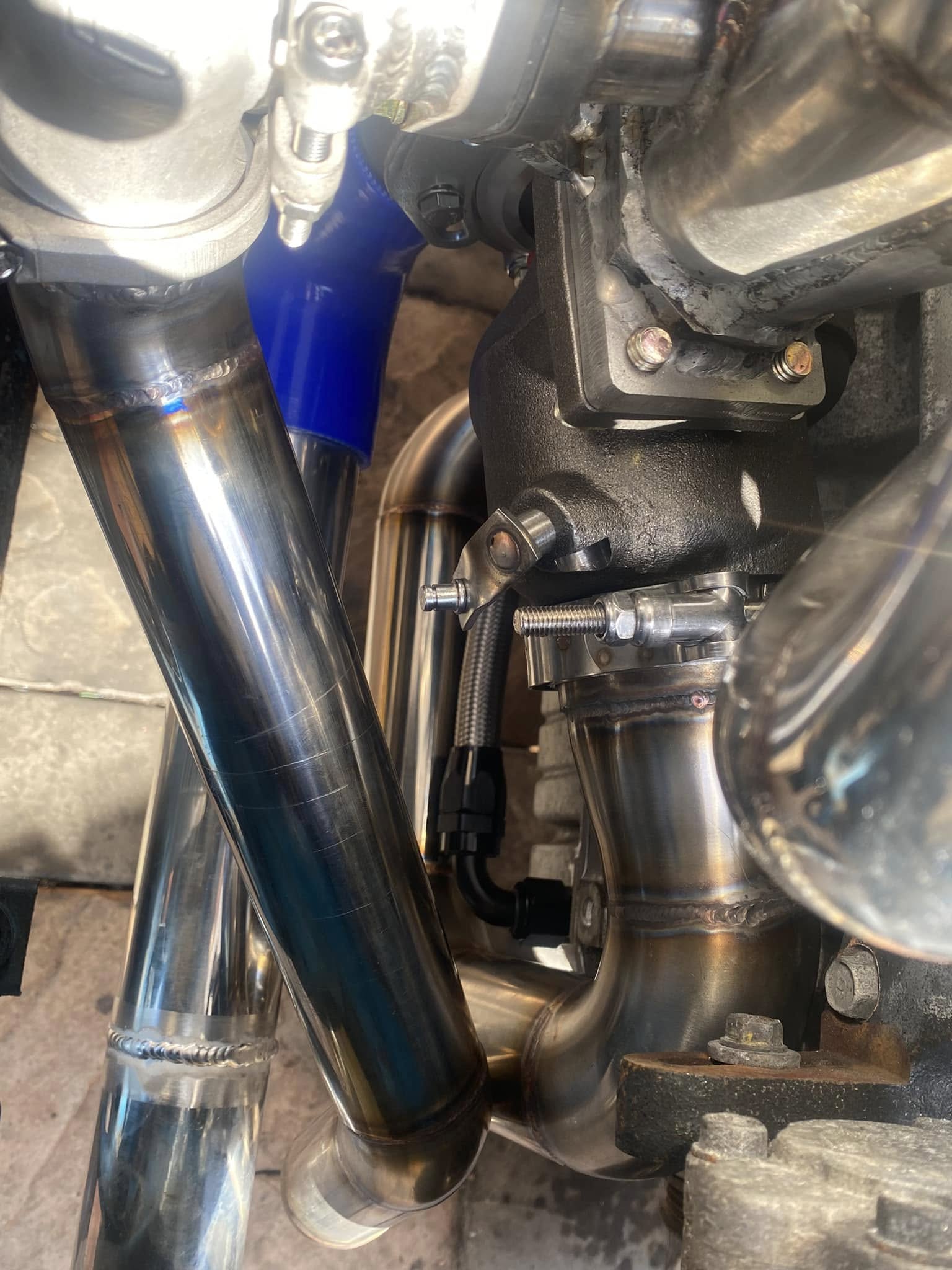 Close-up of installed boost and exhaust pipework around the turbocharger.